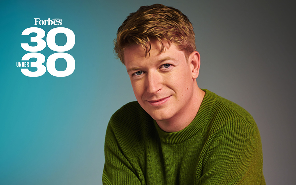 Blue and grey background with a headshot of Sam Crowther, Founder and CEO of Kasada who is posing for Forbes 30 Under 30